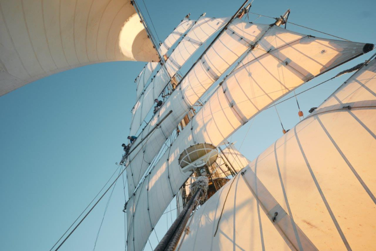 Catching up a fair breeze under full sail over calm seas by Richard Simko