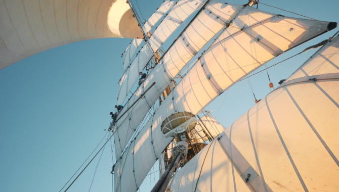 Catching up a fair breeze under full sail over calm seas by Richard Simko