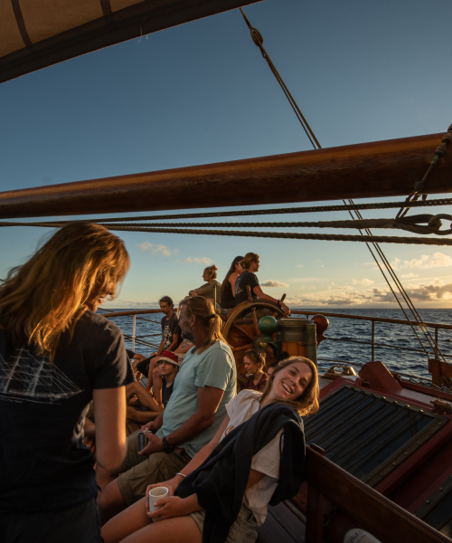 Happy people on board sailing into the sunset