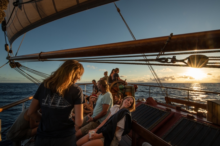 Happy people on board sailing into the sunset