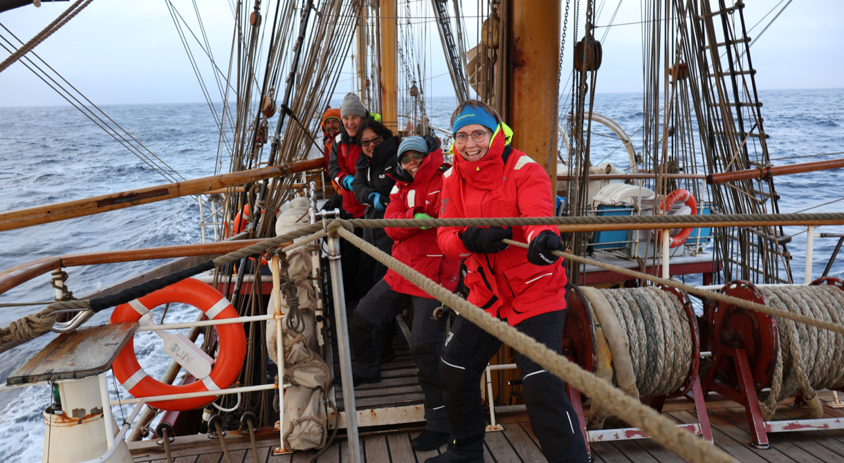 Voyage crew working together on the downhaul to strike the inner Jib: