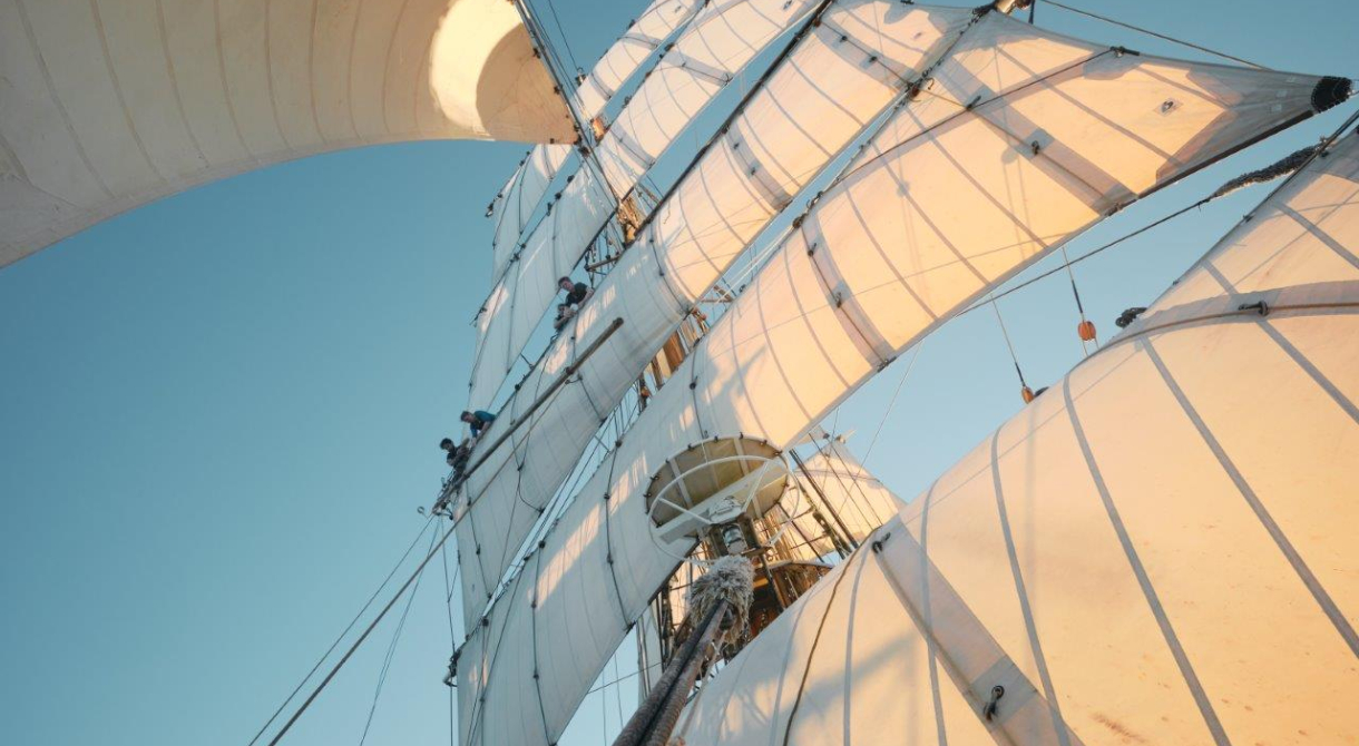 Catching up a fair breeze under full sail over calm seas by Richard Simko