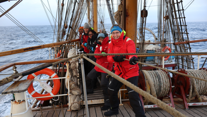 Voyage crew working together on the downhaul to strike the inner Jib:
